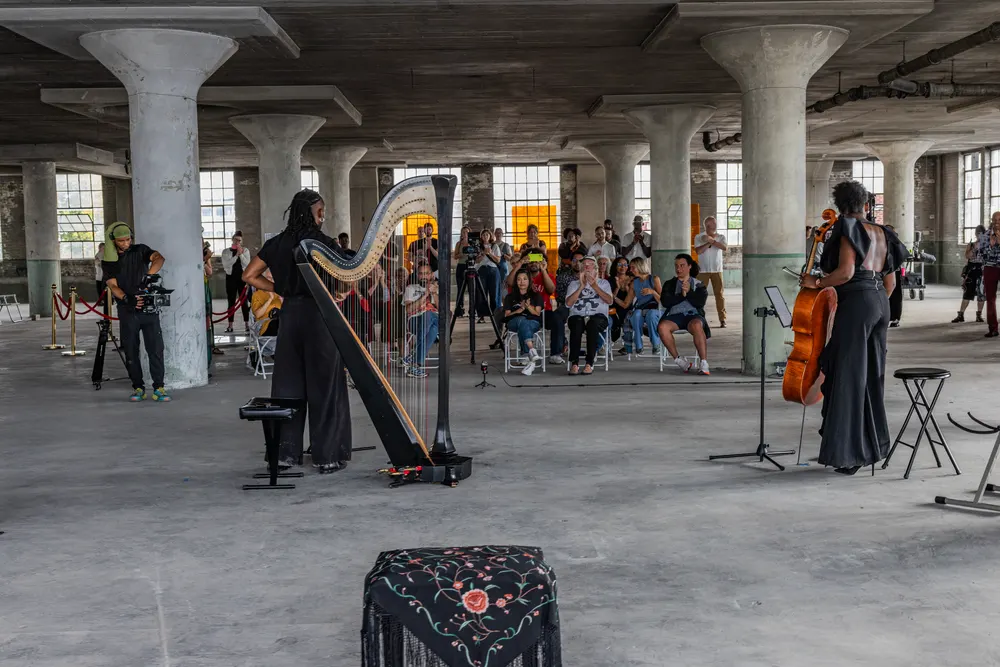 A harp and string performance in a large industrial space