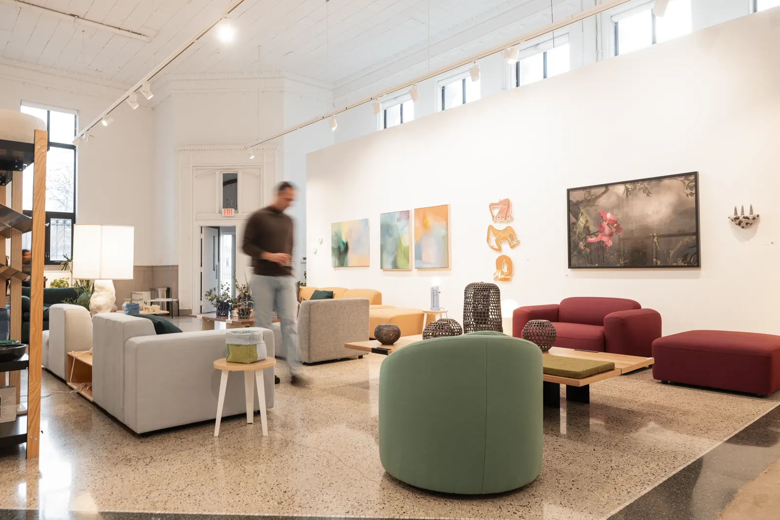 A furniture showroom with original paintings and ceramics on display